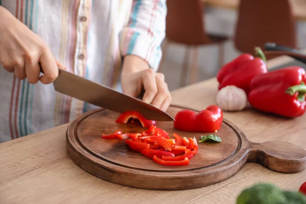 Person cutting red bell peppers